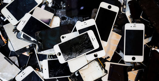 A pile of cell phones are shown with various cracks and imperfections.